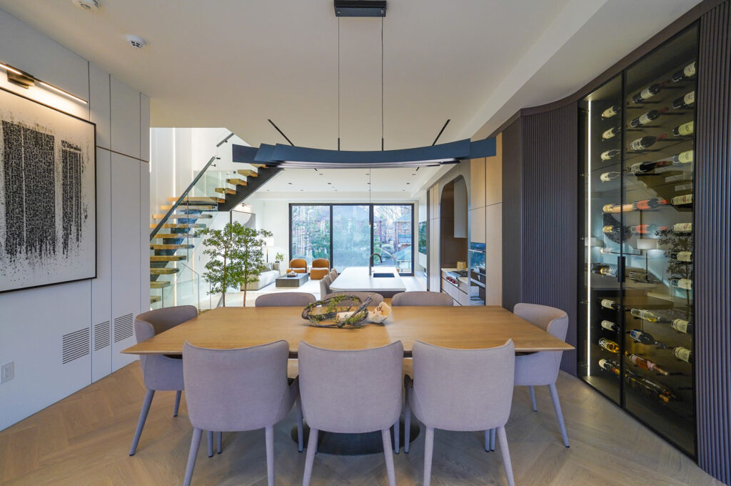 Luxury custom home dining area Toronto with open-concept layout, floating staircase, and built-in wine display
