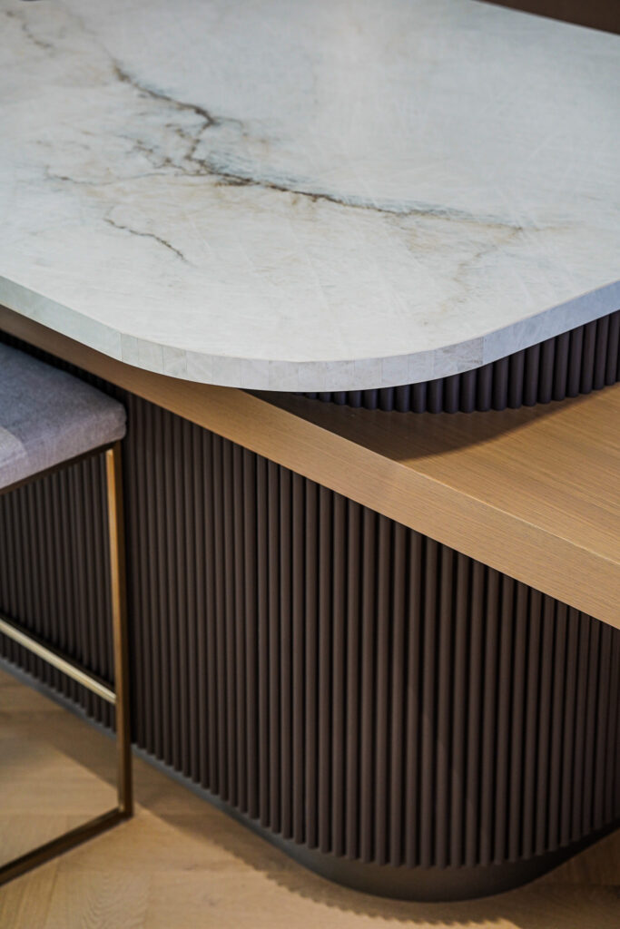 Custom millwork detail Toronto featuring fluted wood cabinetry and marble countertop with rounded edge finish