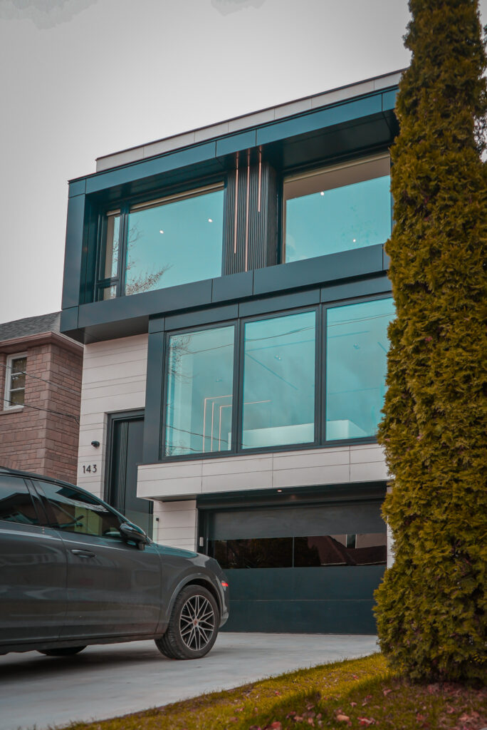 Modern custom home exterior in Toronto with large glass windows, clean lines, and contemporary facade by Khales Corp design-build