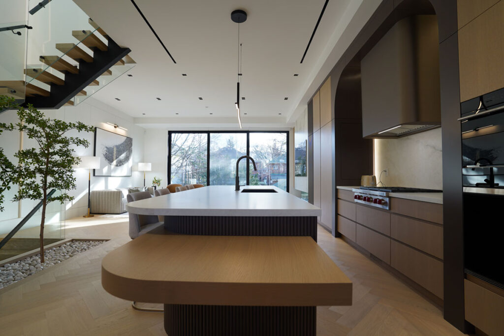 Luxury custom home kitchen Toronto with large island, open-concept layout, and seamless connection to living space and staircase