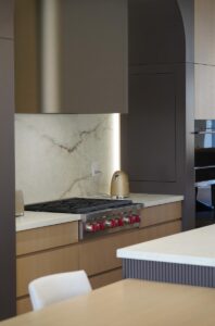 Luxury kitchen Toronto with stone backsplash, built-in stove, and modern cabinetry
