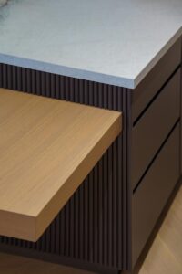 Custom millwork island Toronto with fluted wood paneling and integrated stone countertop
